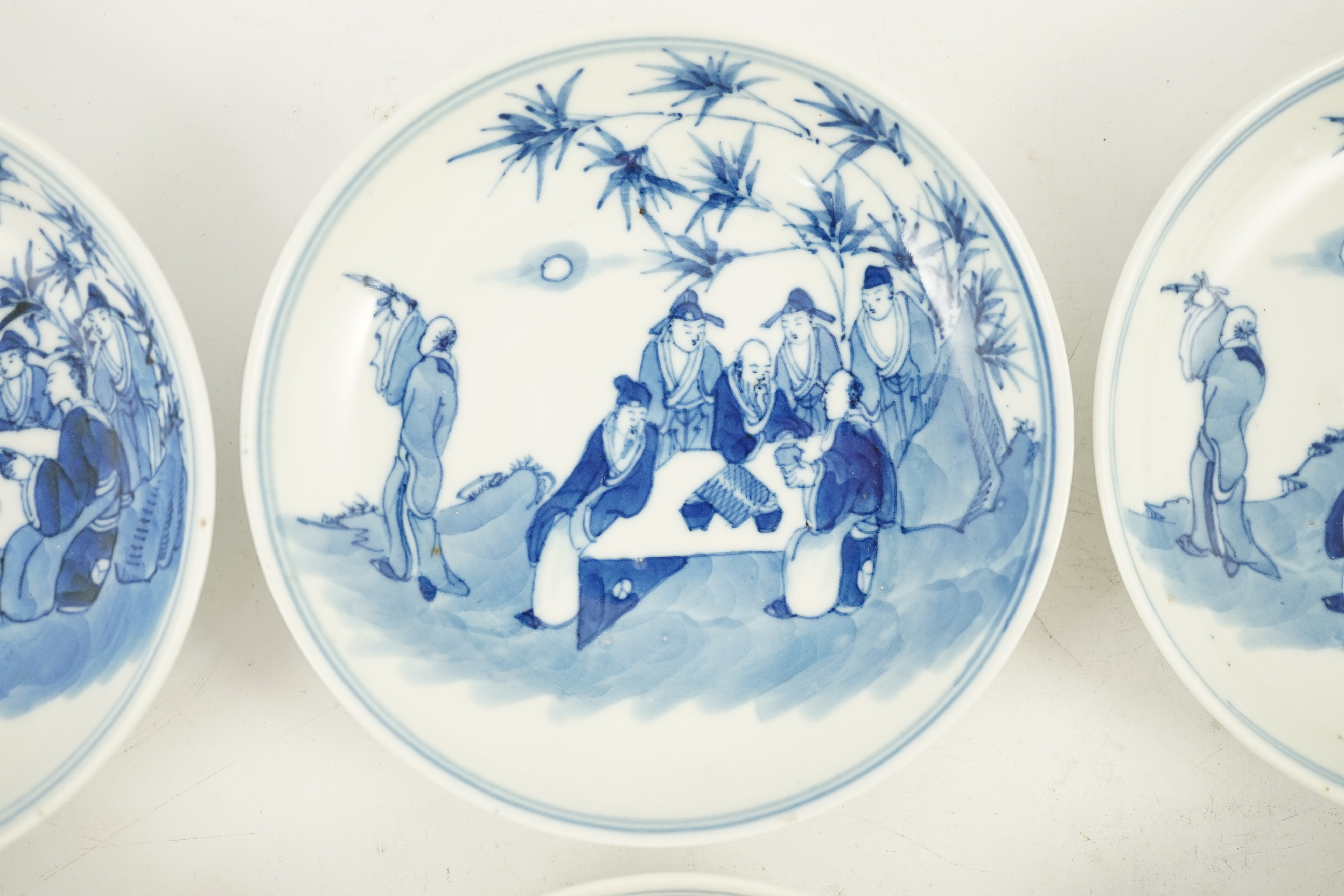 A set of six Chinese ‘Seven Sages of the Bamboo Grove’ saucer dishes, Kangxi marks but late 19th century, 12.3cm diameter